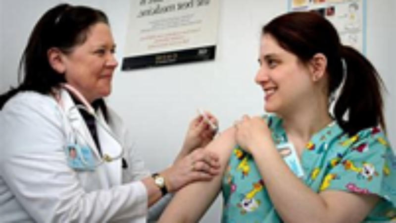 Photograph of a health professional immunising a member of the public.