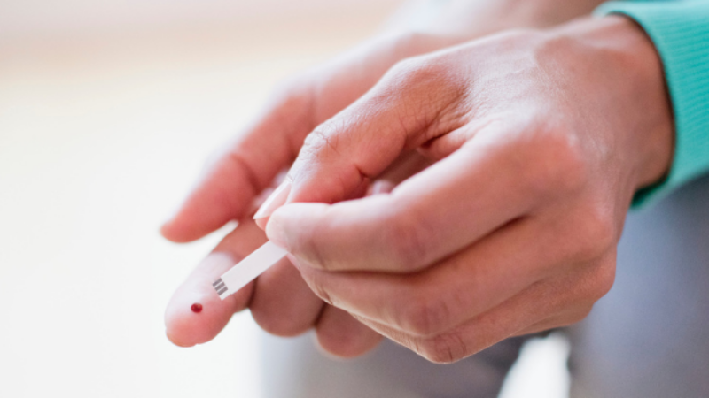 Person pricking themselves for blood test