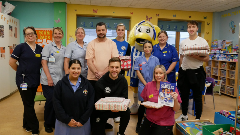 Brighton players with presents alongside Bluefin staff and families